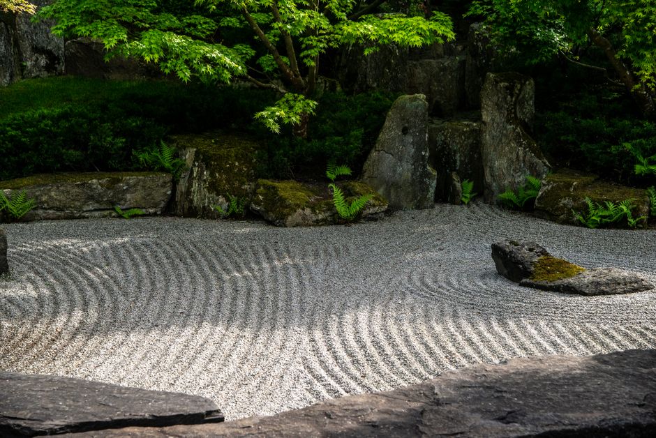 Kaarsen en stenen in zen buitenruimte.